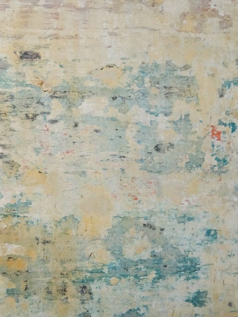 Textura abstracta en tonos suaves, con manchas de azul, amarillo y blanco.