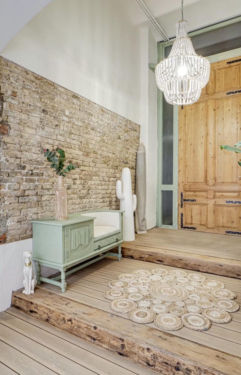 Baño moderno con lavabo de piedra, espejo circular y ducha con iluminación suave.