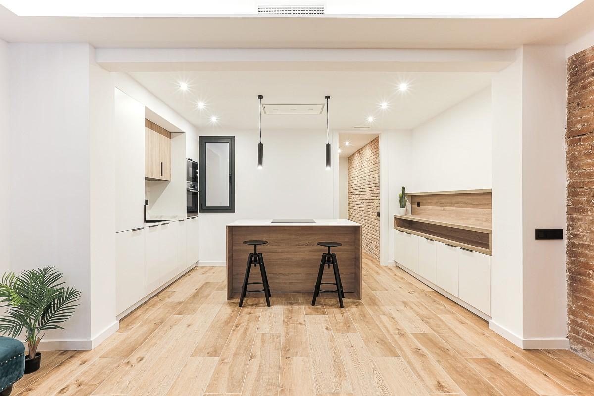 Sala de estar luminosa con sofá, mesa de café y acceso a un balcón. Decoración moderna y acogedora.