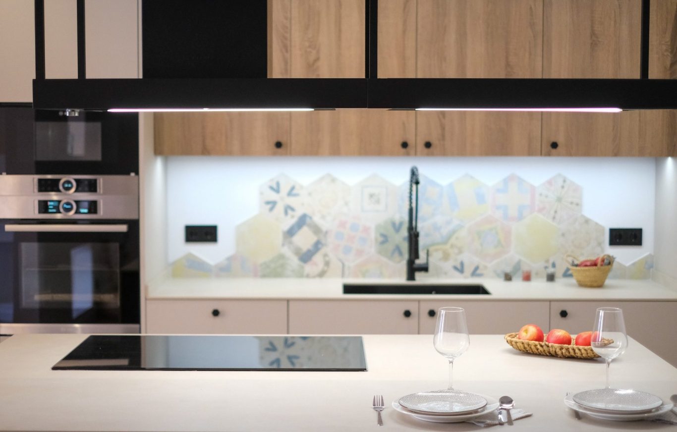 Cocina moderna con azulejos decorativos y electrodomésticos de acero inoxidable.