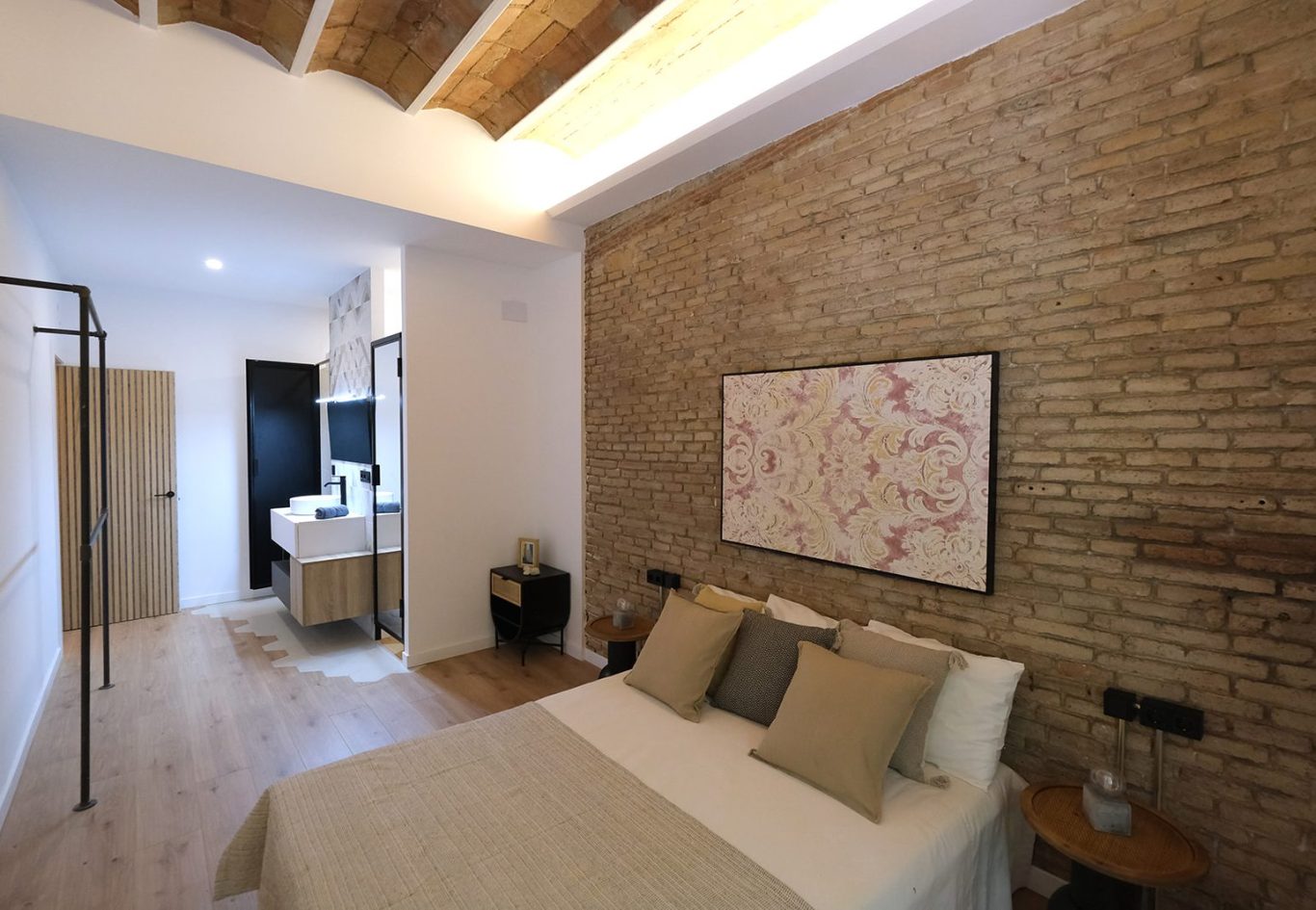 Habitación moderna con paredes de ladrillo y cama con almohadas suaves.