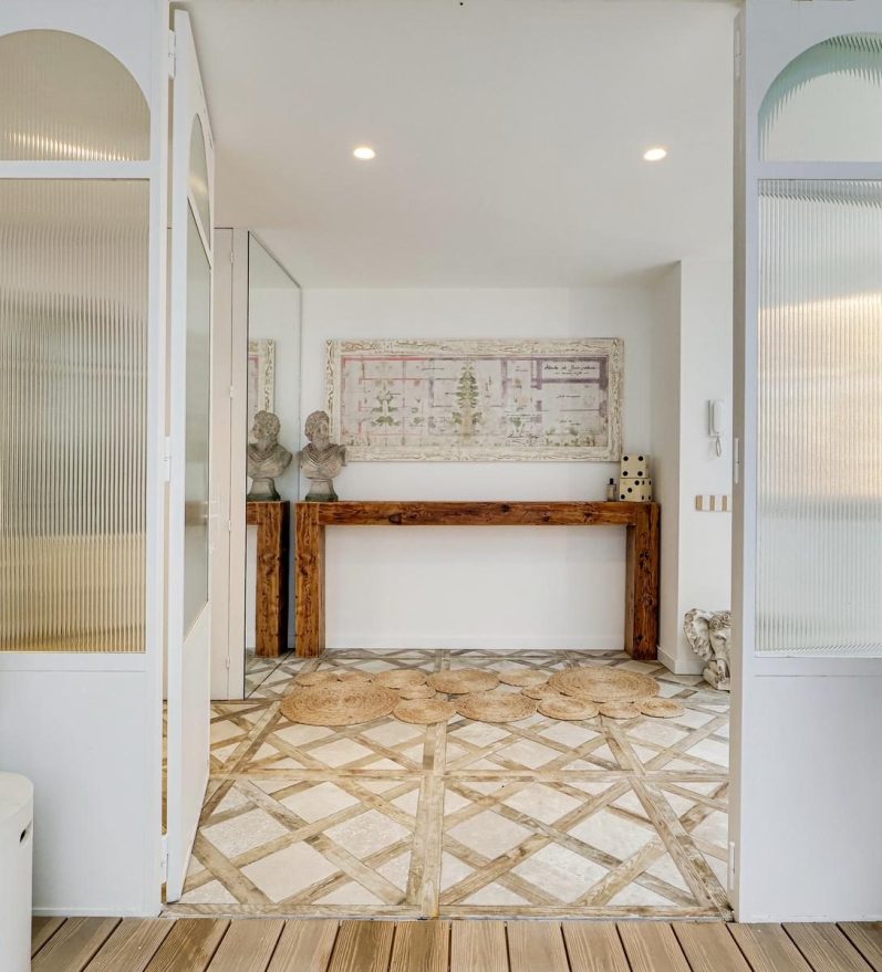 Baño moderno con lavabo de piedra, espejo circular y ducha con iluminación suave.