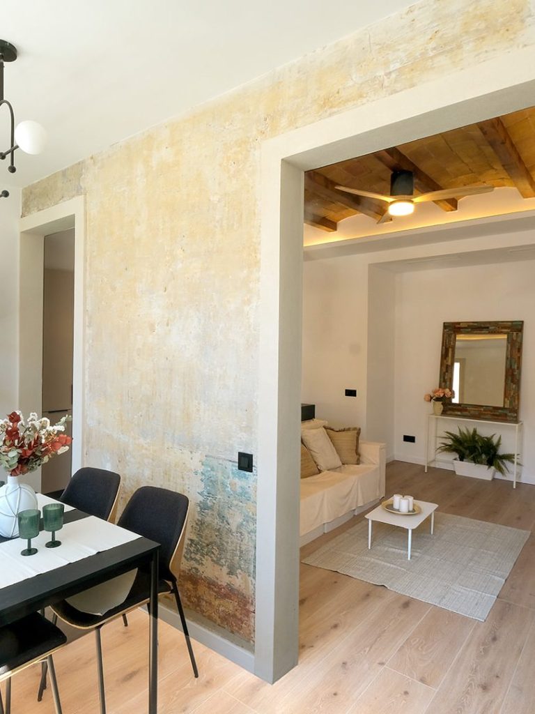 Sala de estar con paredes decorativas y mesa de comedor en un ambiente luminoso y moderno.