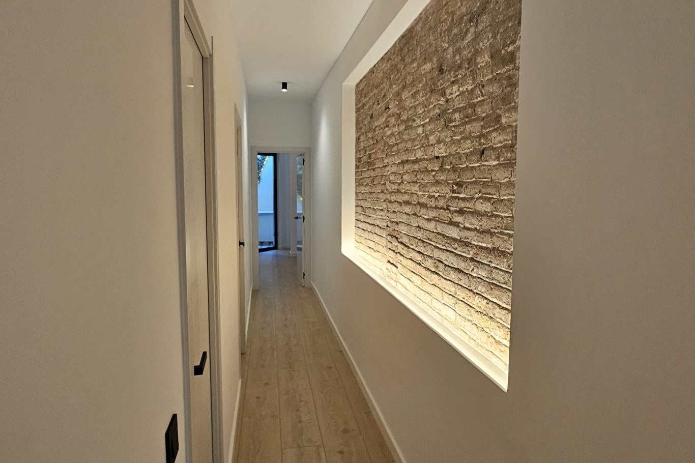 Sala de estar luminosa con sofá, mesa de café y acceso a un balcón. Decoración moderna y acogedora.