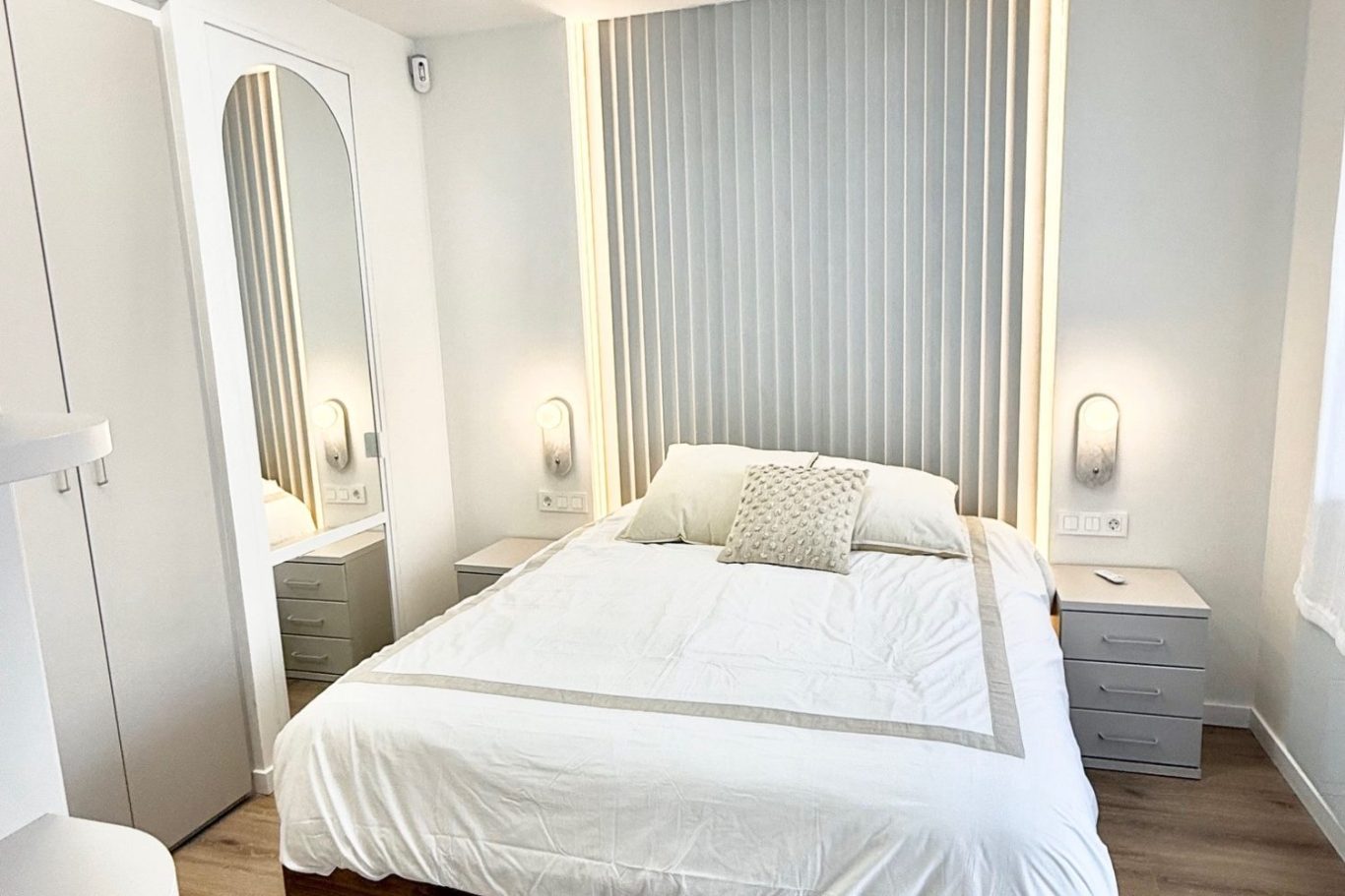 Sala de estar luminosa con sofá, mesa de café y acceso a un balcón. Decoración moderna y acogedora.