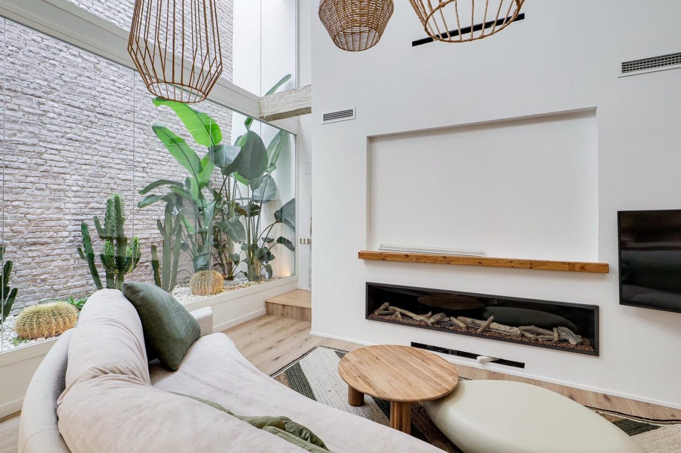 Sala de estar luminosa con sofá, mesa de café y acceso a un balcón. Decoración moderna y acogedora.