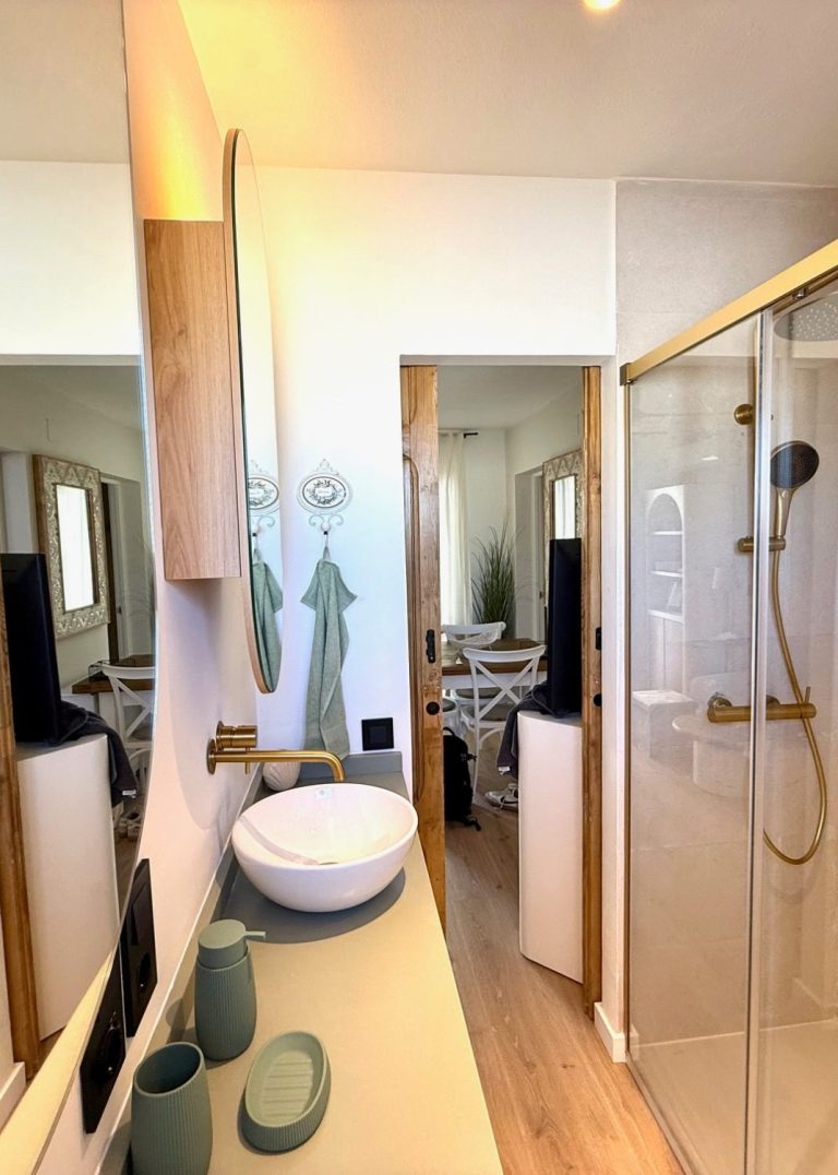 Dormitorio acogedor con cama, ventanas de madera y decoración moderna en tonos claros.