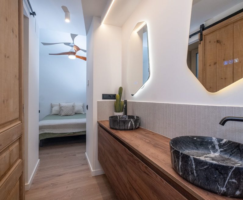 Baño moderno con lavabo de piedra, paredes claras y decoración minimalista.