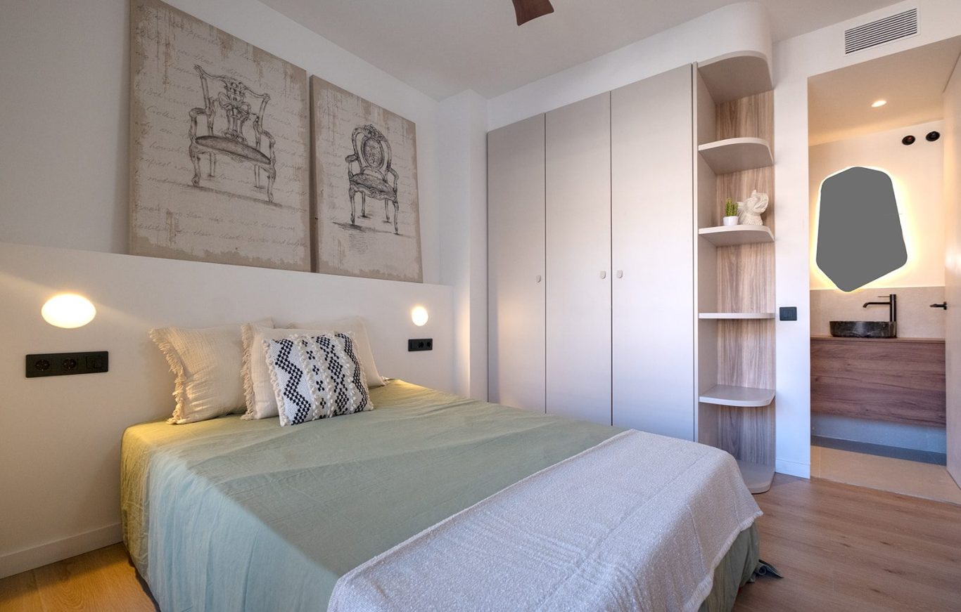 Habitación con cama doble, decoración minimalista y armario integrado.